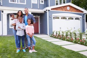 Happy black family standing outside their house