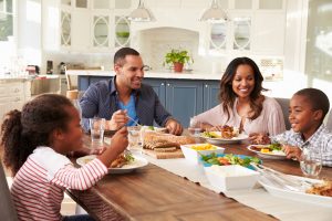 Parents and their two children eating at kitchen table