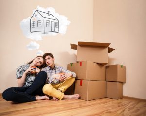 Young couple sitting on the floor and daydream about new home