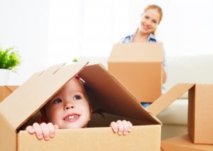 happy family moves into a new apartment. happy baby in a cardboard box
