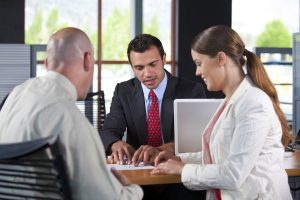 Couple signing loan documents at a bank