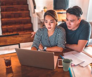 serious-couple-using-laptop-while-sitting-at-home-picture-id1037487390