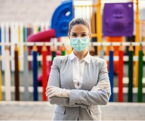 young-woman-with-protective-mask-and-gloves-standing-in-front-of-picture-id1217769992-1